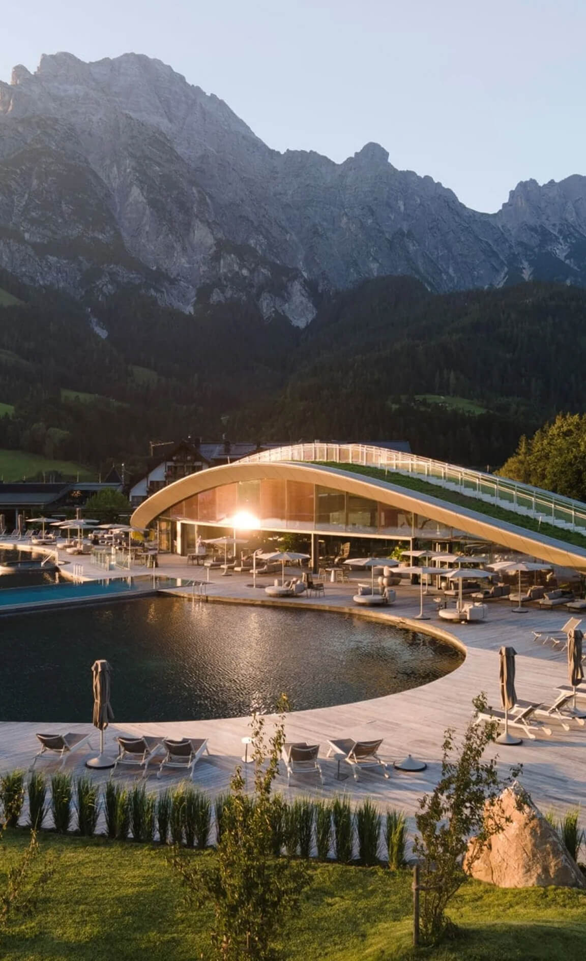 Moderne Architektur am Pool, umgeben von Bergen und Wiesen